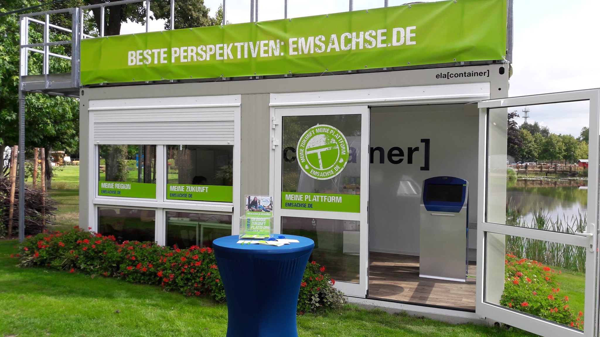 ELA Container auf einer Rasenfläche mit Blumen als Ausstellungsraum auf einer Blumenschau