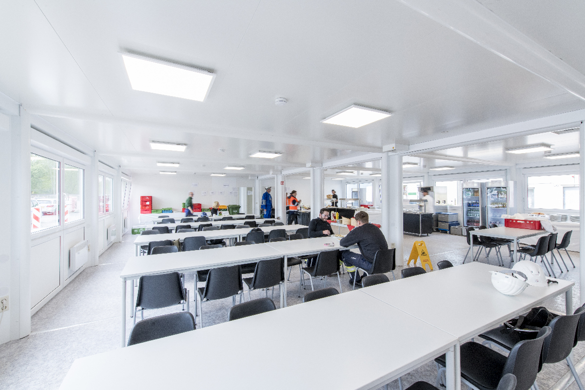 Aufenthaltscontainer von innen mit mehreren Tischen Aufenthaltscontainer von innen mit mehreren Tischen