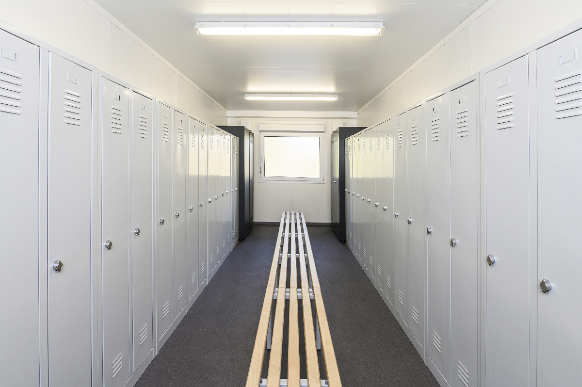 Umkleidecontainer von innen mit Bank in der Mitte und rechts links Spinde Umkleidecontainer von innen mit Bank in der Mitte und rechts links Spinde