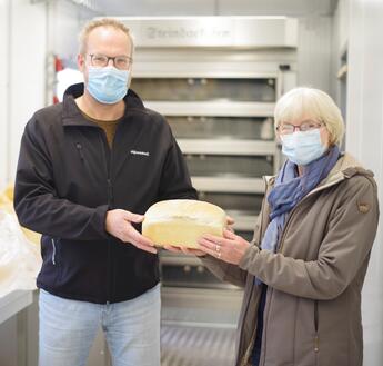 Vertriebsmanager Markus Arling übergibt die in dem mobilen Bäckereicontainer hergestellten Brote an Marianne Ströer von der Harener Tafel.