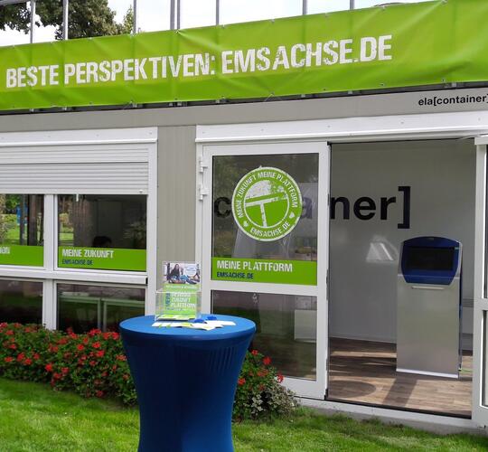 ELA Container auf einer Rasenfläche mit Blumen als Ausstellungsraum auf einer Blumenschau