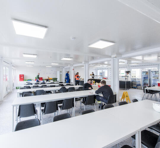 Aufenthaltscontainer von innen mit mehreren Tischen