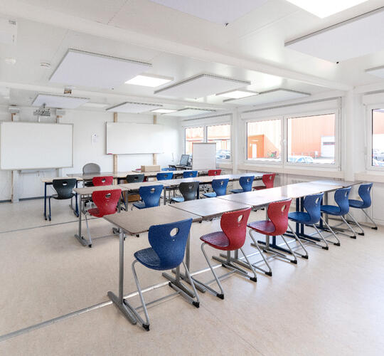 Schulcontainer-Innenansicht-mit-Tischen-und-Stühlen