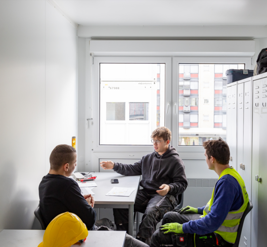 Kollegen unterhalten sich im Mannschaftscontainer