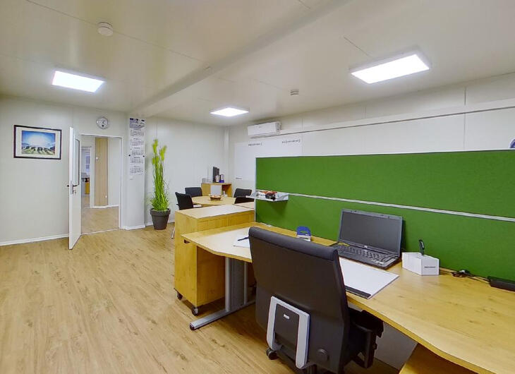 Bürocontainer mit Schreibtisch und Sichtschutz