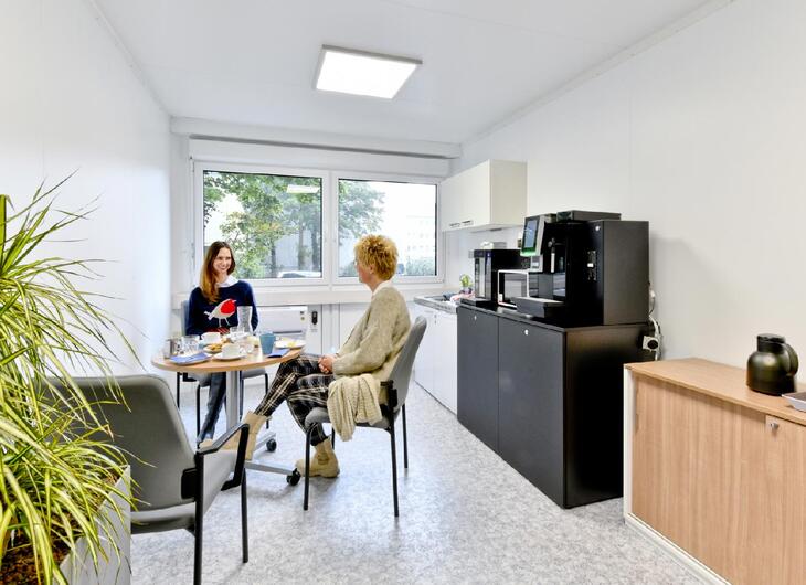 Aufenthaltscontainer von Innen mit Küchenzeile und Sitzecke