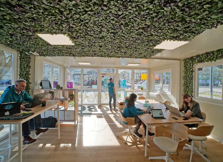 Aufenthaltscontainer mit Schreibtischen und Personen