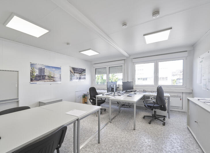 Bürocontainer mit zwei Schreibtischen und Bürostühlen