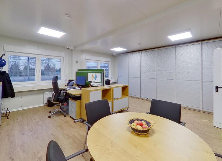 Bürocontainer mit Schreibtischen und Aufenthaltstisch