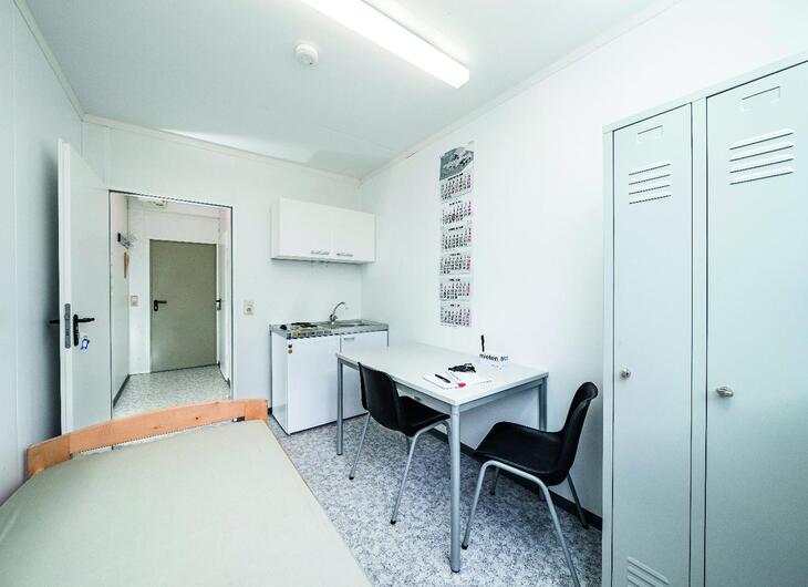 Wohncontainer mit Küchenzeile, Bett und Aufenthaltsbereich