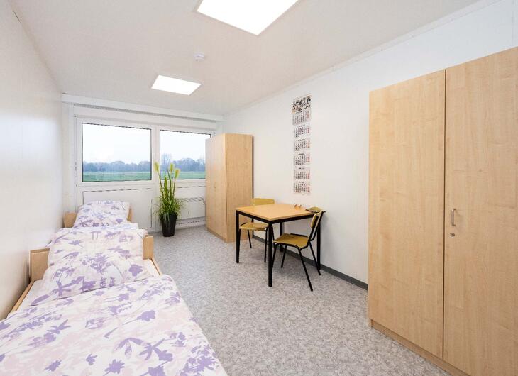 Wohncontainer innen mit Bett, Tisch und Schrank Wohncontainer innen mit Bett, Tisch und Schrank