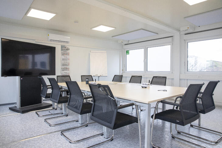 Besprechungsraum von innen mit großem Tisch und Fernseher