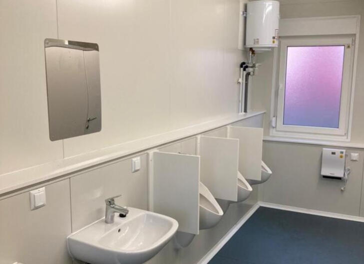 Sanitärcontainer-von-innen-mit-blick-auf-waschbecken-und-stehwc