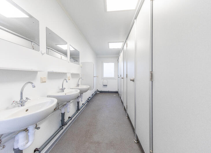 Sanitärcontainer-von-innen-mit-blick-auf-wcs und waschbecken