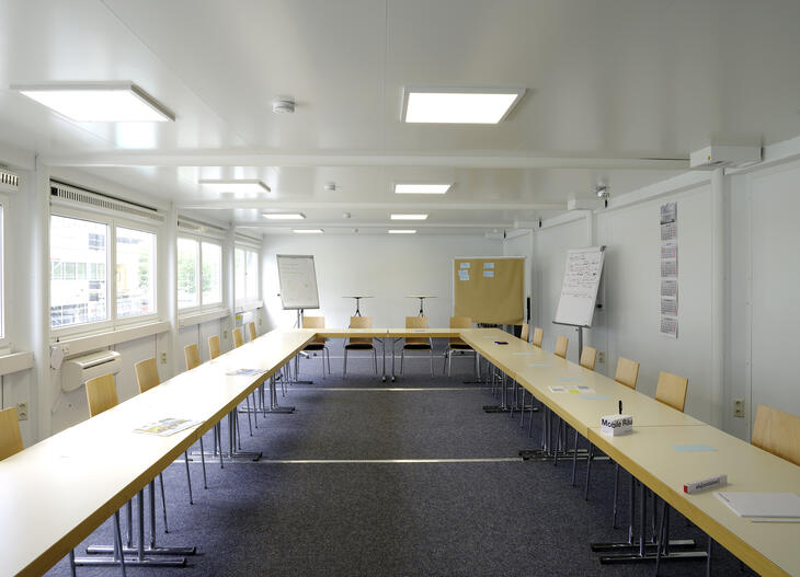 Innenansicht Klassenzimmer Schulcontainer hellbraune Tische und Stühle - ELA Container