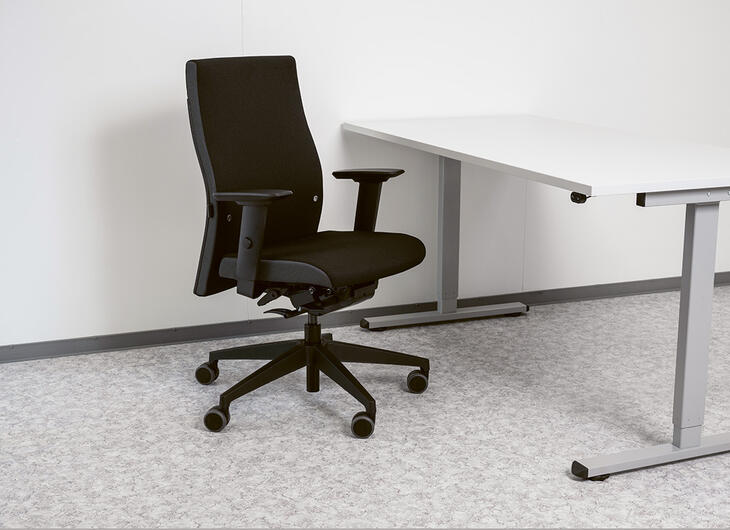 Ergonomischer Stuhl vor einem Tisch Ergonomischer Stuhl vor einem Tisch