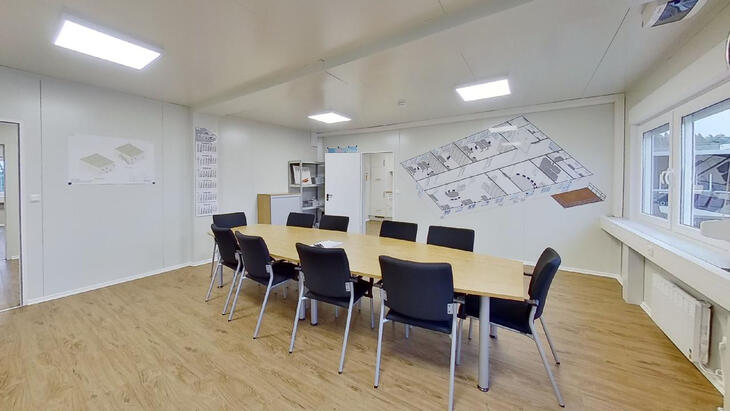 Bürocontainer mit Schreibtisch und Stühlen