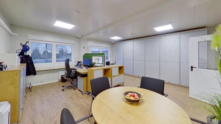 Bürocontainer mit Schreibtischen und Aufenthaltstisch