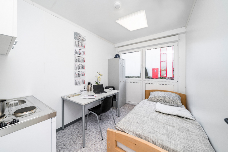 Wohncontainer mit Bett und Schreibtisch und Küche