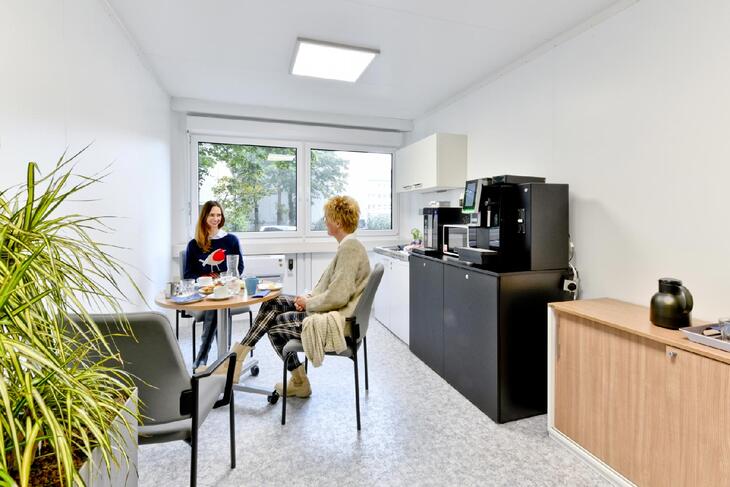 Aufenthaltscontainer mit Küche und Sitzbereich