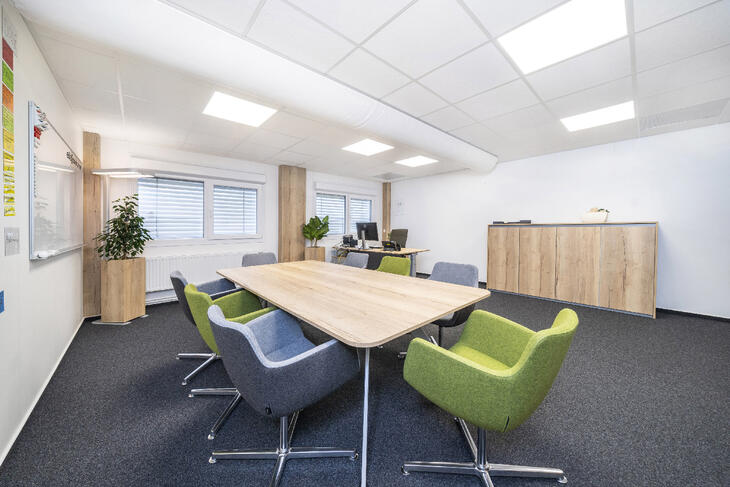 Besprechungsraum mit Filzboden, Tisch, Stühlen und Schreibtisch Besprechungsraum mit Filzboden, Tisch, Stühlen und Schreibtisch